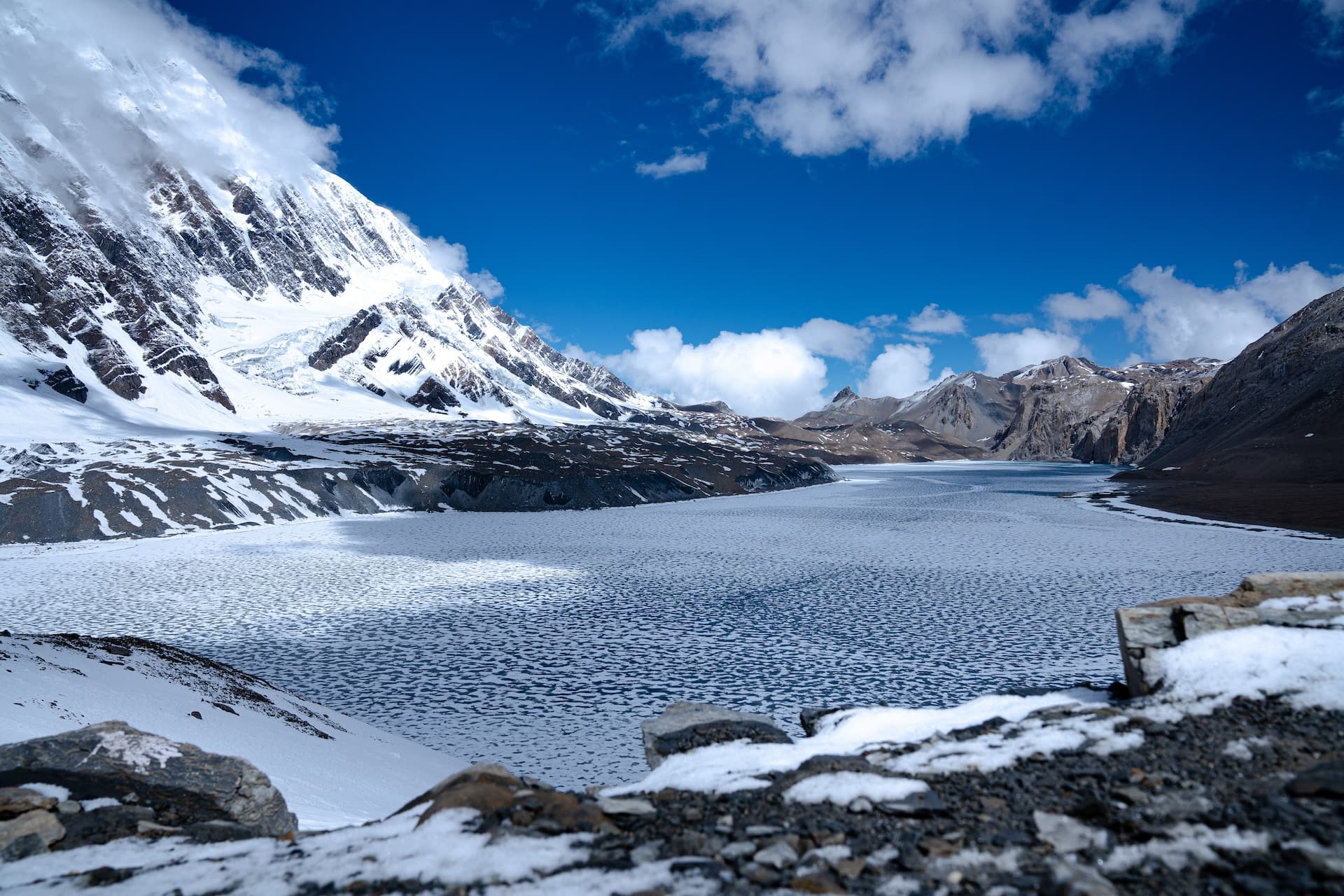 snow covered lake with mountain in background