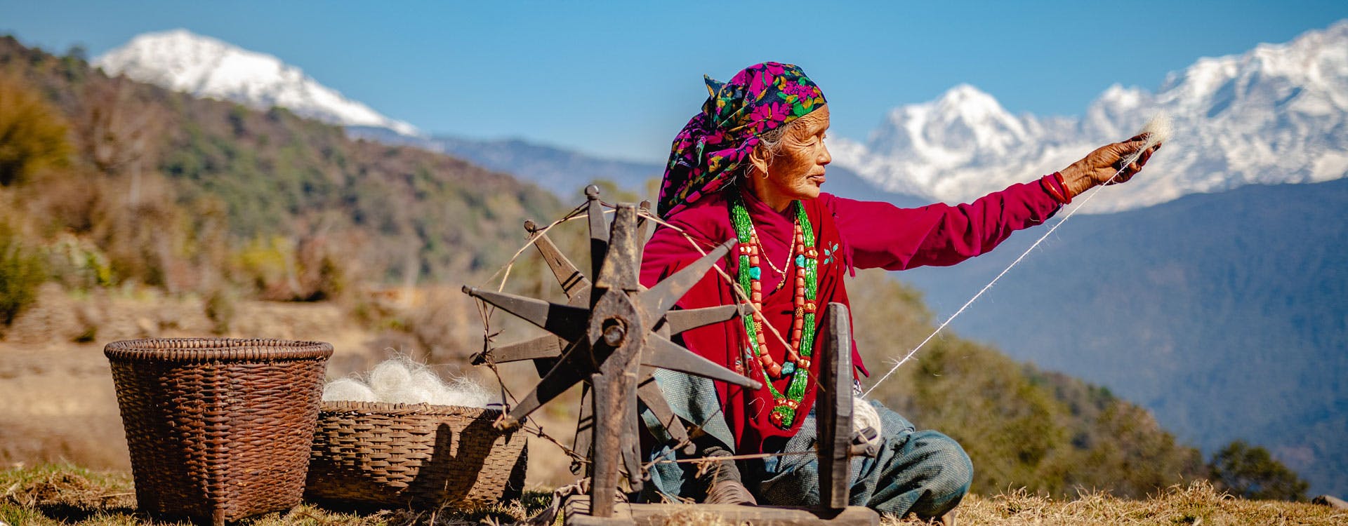 Women making woolen clothes in front of the Himalaya range in Nepal
